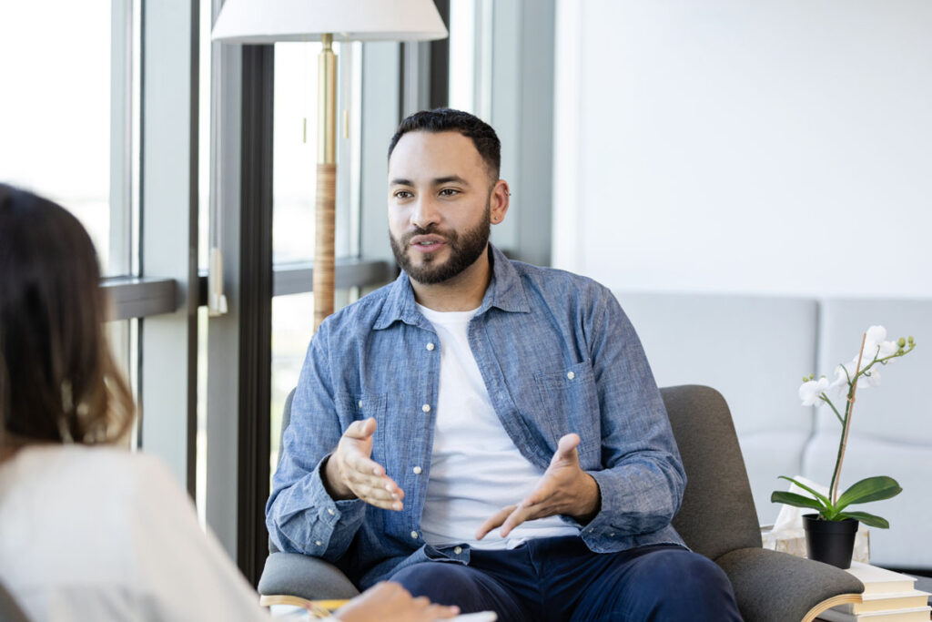 man sitting in chair talking to a doctor