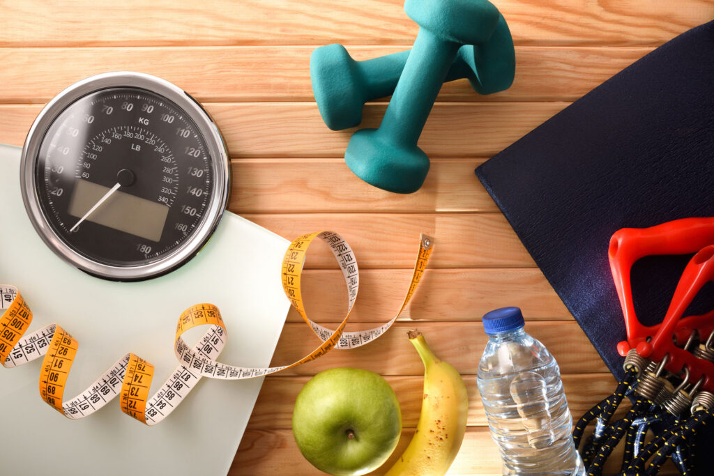 Wellness and health with sports accessories and weight control equipment for healthy life and lose on wood floor. Top view. Horizontal composition.